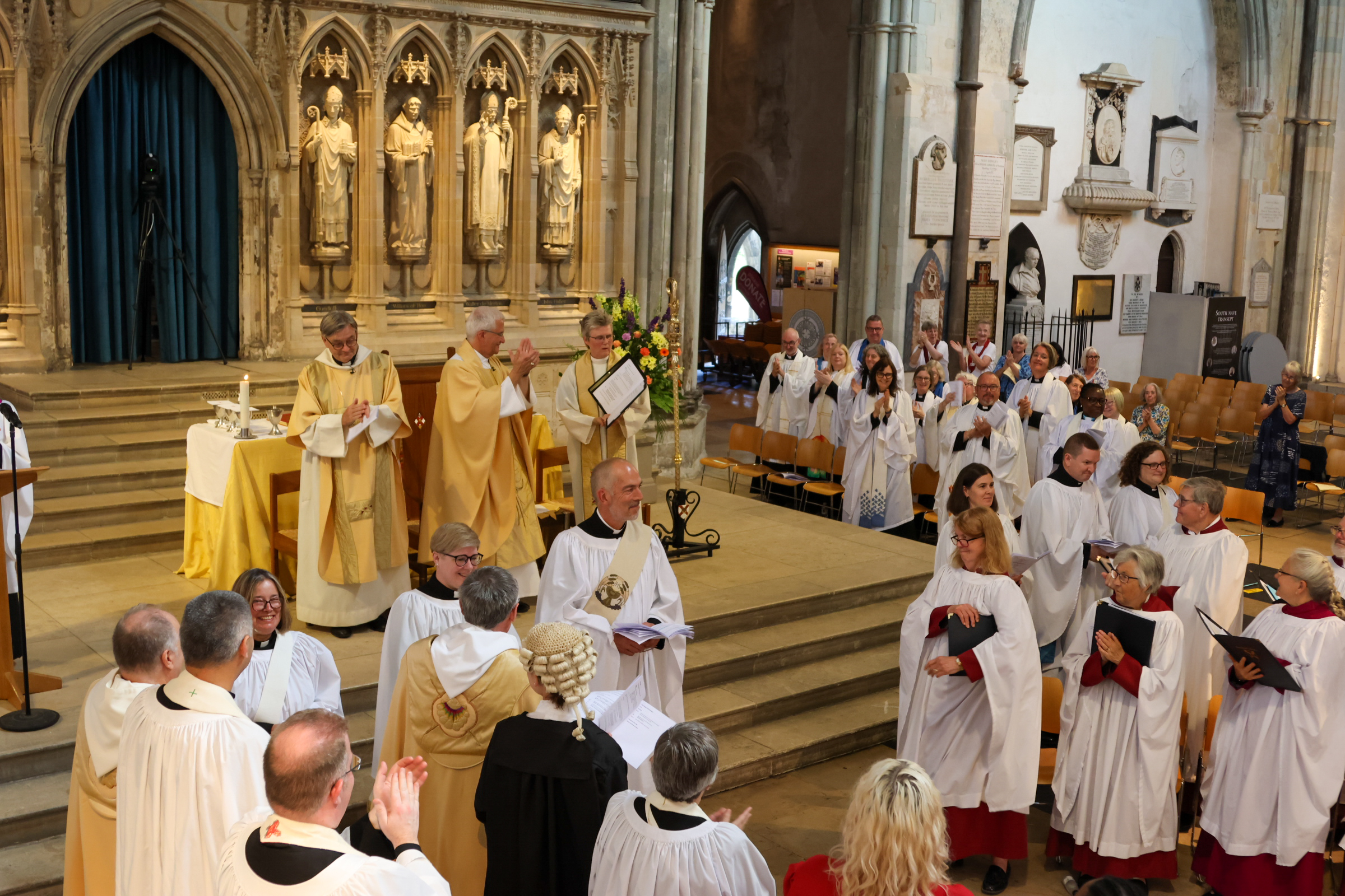 The deacons stand in the Cathedral and are applauded by the congregation