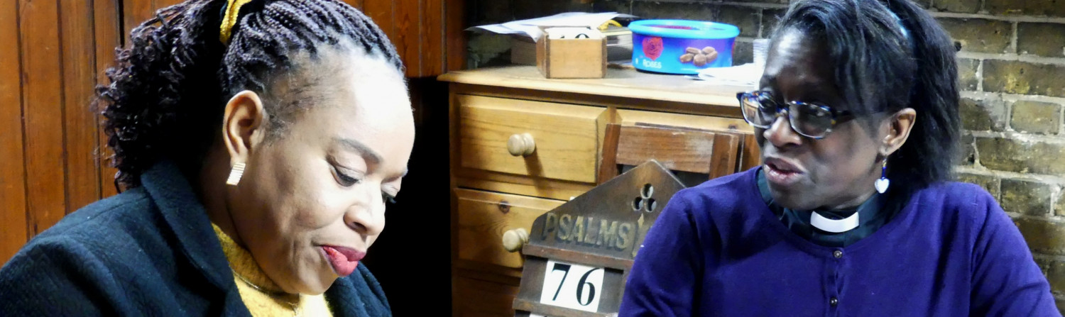 A lay minister and member of clergy sit and discuss calendar dates.